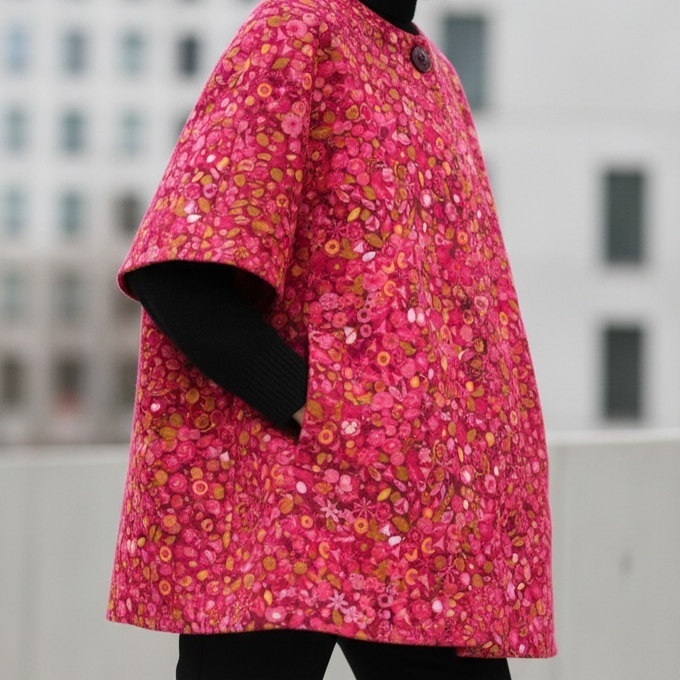 Tissu coton aux motifs floraux stylisés rose framboise et orange, pour un look moderne et vitaminé, disponible chez Mille et Un Tissus à Moulins.